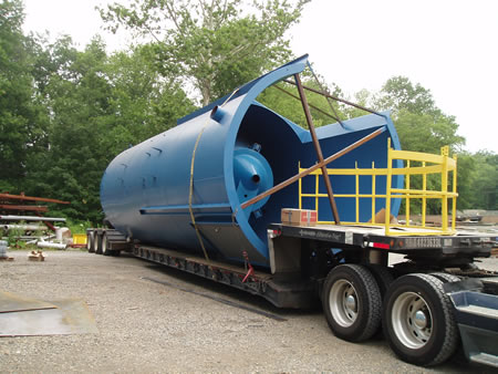 A steel drum on the back of a flatbed trailer